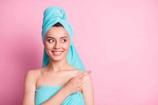 Photo of nice pretty young lady pointing empty space wear teal bath towels on head body isolated on pink color background