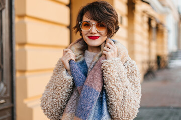 Stunning woman with scarf posing on street. Outdoot shot of european young lady in coat.