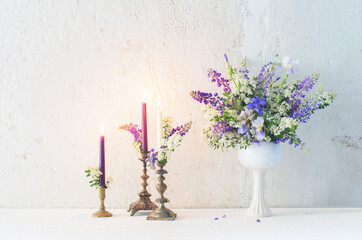 flowers and candles on background white wall