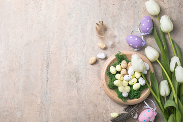 Easter composition with colorful Easter eggs and spring flowers  tulips on concrete background. Easter card  copy space