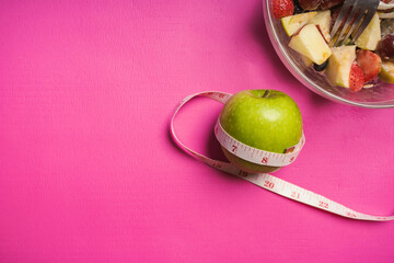 Healthy food fitness, Green apple with salad fruit on pink yoga mat. Health care, exercise concept.