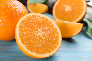 Delicious ripe oranges on light blue wooden table, closeup