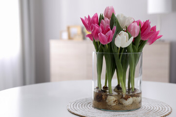 Fototapeta na wymiar Bouquet of beautiful tulips with bulbs on table indoors. Space for text