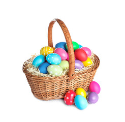 Fototapeta na wymiar Wicker basket with bright painted Easter eggs on white background