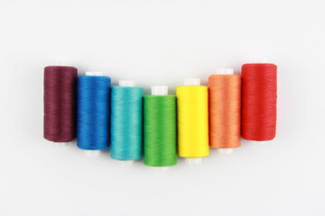 Colored, rainbow threads for sewing with a needle. The concept of handmade. Top view. Flatlay. Copyspace.