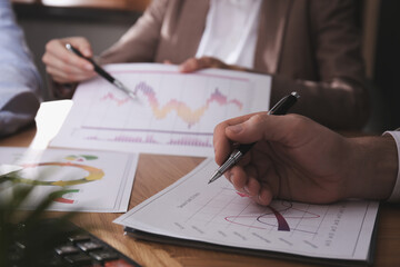 Naklejka premium Business people working with charts and graphs at table in office, closeup. Investment analysis