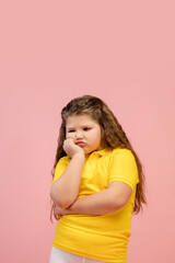 Offended. Happy, smiley little caucasian girl isolated on coral pink studio background with copyspace for ad. Looks happy, cheerful. Childhood, education, human emotions, facial expression concept.