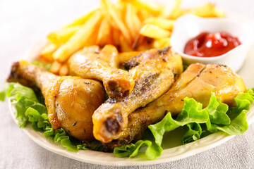 grilled chicken leg,  french fries and ketchup