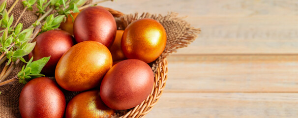 Happy Easter. Shiny golden eggs in a wicker basket and willow twigs