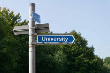 Obraz premium Street sign pointing in the direction of a University