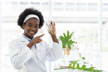 African American girl scientists holding glassware for tests of plants in the classroom. Kid learning science and doing analysis in the laboratory. Science experiment. Early development of children
