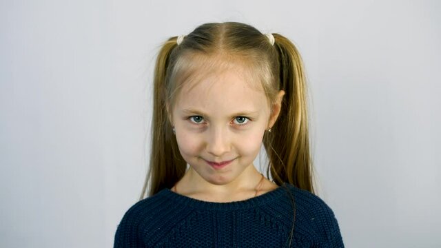portrait of a little girl isolate on a white background. The girl is angry and smiling