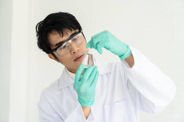 Scientists tests of plants in laboratory. Asian male scientists holding, doing analysis for germs and bacteria with glassware in the laboratory. Scientific experiment. researcher and discovery concept