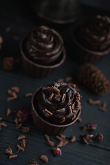 Muffin or cupcake with chocolate shaped cream at black table. Flatlay top view