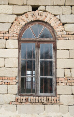 Old wooden arched window with metal grate close up