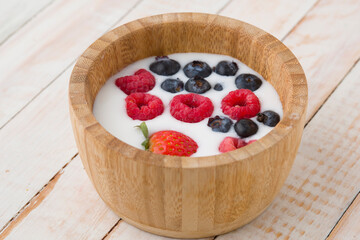 Yogurt vegano con frutas en tazón de madera rustico
