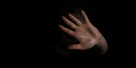 woman with raised hand on black background. isolated on black background