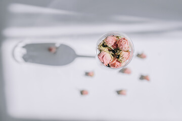 Pink roses in a glass on a white background top view
