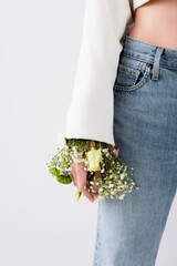 Cropped view of woman with flowers in sleeve of jacket isolated on grey