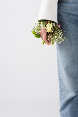 Cropped view of woman with small flowers in sleeve of jacket isolated on grey