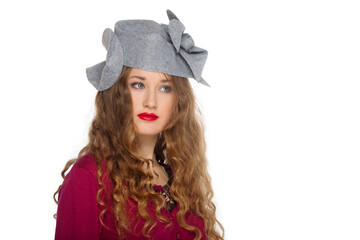 Potrtait of a beautiful elegant young teenager girl with long curly hair in a felt designer pill hat isolated on white background.