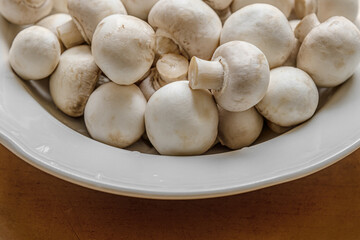 fresh raw champignons on white plate close up
