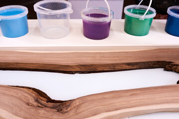 Process making of a craft resin and wood table. Liquid epoxy is poured into a mold with wooden...