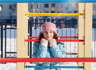 Happy smiling young woman on the playground in the winter holidays. Winter sport pastime in the...