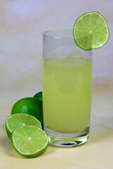glass of water with lime juice and slices of fresh lime 