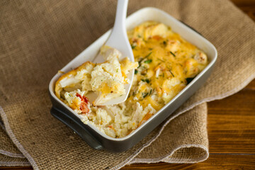 baked cauliflower with chicken fillet and vegetables topped with cheese