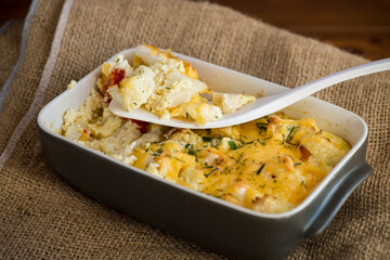 baked cauliflower with chicken fillet and vegetables topped with cheese
