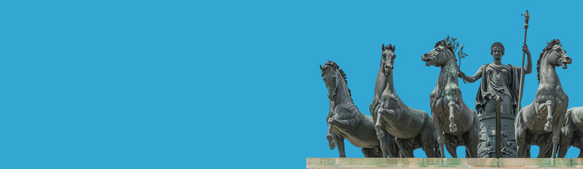 Fototapeta na wymiar Banner with statue of Goddess Victoria with horses at the top of Triumphal Arch called Arch of Peace in Milan historical downtown, Sempione Park, Italy, at blue sky background with copy space