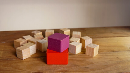 purple wooden block on a red block around another wooden block. Nomination concept.