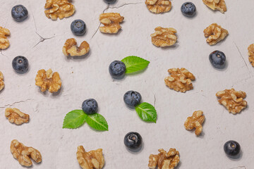 Fresh blueberries and shelled walnuts on a gray background. Natural products concept