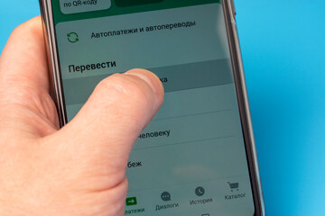 Hand selects bank transfer money in smartphone app, modern cashless payment