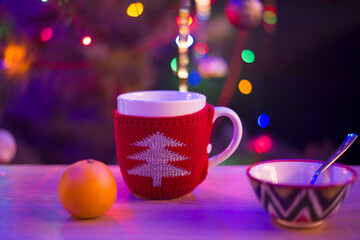 big red mug on the background of the Christmas tree