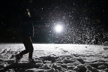 Little girl playing in the snow on winter’s night