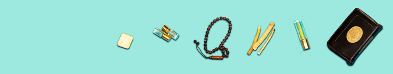 holy book of muslims and siwak ( tooth brush ) and perfume, rosary on blue background. happy ramadan concept