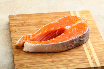 Raw salmon steak over board
