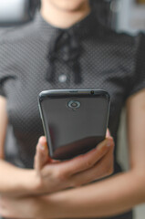 Smartphone in a female hand. A woman holds a mobile phone in her hand.