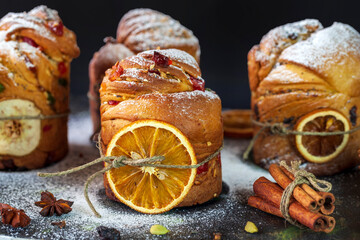 Easter cake Kraffin (Cruffin), with nuts and candied fruit sprinkled with powdered sugar on a black background, 2021 trend of the easter cake.