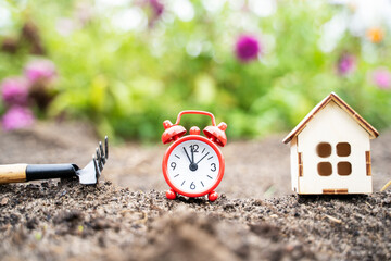 clock alarm clock and house on the ground, harvest concept