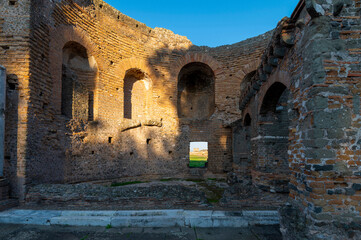 Fototapeta premium Detail of the apse of Nymphaeum of the Villa dei Quintili on the Appia Antica in Rome, on a sunny summer day and blue sky with the window. The regina viarum that connected Rome to Brindisi, Italy.