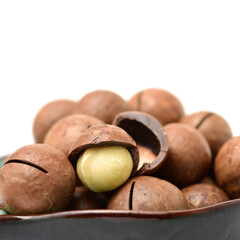 Shelled and unshelled macadamia nuts on white background
