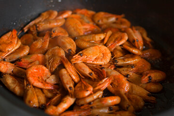 Grilled fresh shrimp, fried with spices and butter. Close-up of fried shrimp in a frying pan