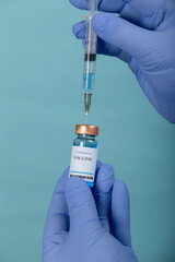 A doctor in blue gloves collects a medicine in a syringe. vaccine testing.