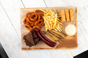 set of beer snacks. Fried sausages, French fries, croutons, onion rings, cheese sticks.