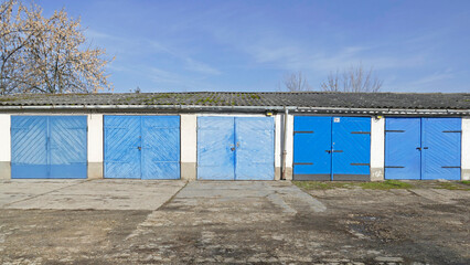 Garages with closed blue doors. Many shades of blue.