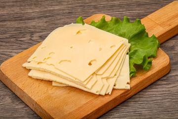 Sliced yellow cheese over board