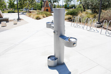 A view of a modern water fountain with a drinking area close to the ground, good for pets, seen at...